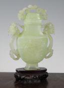 A Chinese pale green bowenite vase and cover, of flattened baluster form, each side carved in relief
