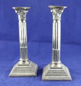 A pair of 1960`s silver corinthian column candlesticks, with fluted filleted columns, on stepped