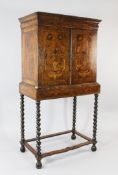 A William & Mary style walnut and marquetry inlaid cabinet on stand, with a pair of cupboard doors