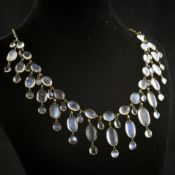 A gold and graduated moonstone drop fringe necklace, set with sixty oval or round cabochon stones,