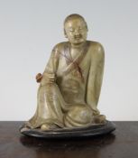 A Chinese greenish cream soapstone seated figure of a Luohan, 18th century, holding a ruyi sceptre
