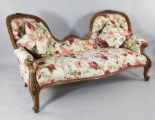 A Victorian carved walnut double chair back settee, with floral buttoned upholstery, on scroll legs