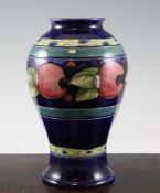 A Moorcroft `Pomegranate` baluster vase, c.1928, banded borders on cobalt blue ground, inscribed `