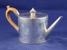 A George III silver teapot, of cylindrical form, with engraved armorial and decorated borders,
