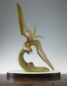 A French Art Deco patinated spelter model of a tern on a crest of a wave, on an oval green onyx