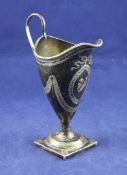 A George III silver helmet shaped cream jug, with beaded border, loop handle and engraved initial
