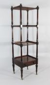 An early 19th century mahogany four tier whatnot, with stiff leaf carved columns, single base