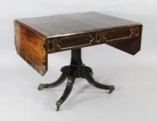 A Regency rosewood and coromandel cross banded sofa table, the drop leaves with canted corners on
