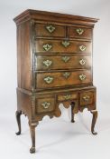 An 18th century oak and mahogany chest on stand, fitted with an arrangement of five drawers