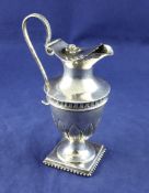 A late 18th century Russian silver urn shaped cream jug, with leaf decoration, beaded loop handle