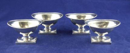 A set of four George III silver oval pedestal salts, with reeded borders, on oval foot and