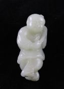 A Chinese pale celadon jade figure of a standing boy, 18th / 19th century, holding a sprig of