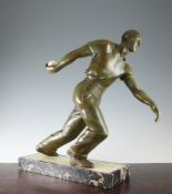 A French Art Deco green patinated spelter model of a boules player, holding an ivory boule in his