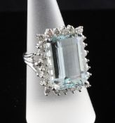 A white gold aquamarine and diamond cluster dress ring, the rectangular cut aquamarine bordered by