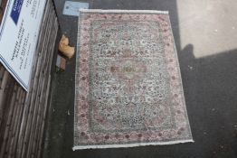 A Tabriz carpet, with central medallion in a field of scrolling foliage, on a pink and beige ground,