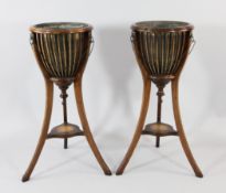 A pair of Edwardian mahogany jardiniere stands, each with brass liners, lion mask handles and
