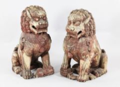 A pair of South East Asian painted wood Buddhist temple lion figures, each carved in seated pose,