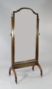 A mahogany and boxwood strung cheval mirror, with bevelled glass mirror plate, on brass castor feet,