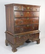 A George II walnut chest on stand, with three secret frieze drawers over a further arrangement of