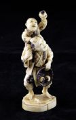 A Japanese walrus ivory group of a persimmon seller, early 20th century, with a boy perched upon his