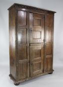 A 17th century oak panelled cupboard, with single door and geometric decoration, W.4ft 2in.