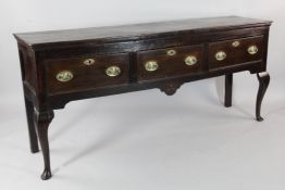 An 18th century elm and oak dresser base, fitted three drawers, on cabriole legs and pad feet, W.5ft