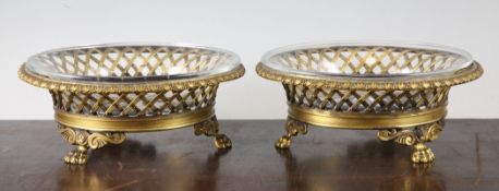 A pair of French ormolu and glass lined sweetmeat dishes, with pierced basket weave bodies, on