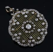 A Belle Epoque gold, silver and diamond set openwork pendant/brooch, of shaped circular form, the