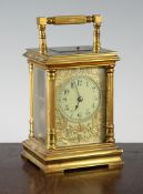 An Edwardian gilt brass hour repeating carriage clock with pierced fret cut brass and enamel dial,