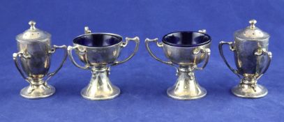 A stylish Art Nouveau Edwardian silver four piece condiment set, comprising two pedestal salts and