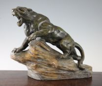 A French Art Deco painted terracotta model of a tiger on rocks, signed and numbered, with a paper