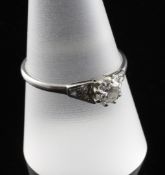 A 1920`s platinum and solitaire diamond ring, with diamond set shoulders, the central stone weighing