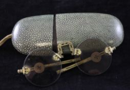 A pair of Chinese brass framed folding spectacles, rock crystal lenses, with a shagreen covered