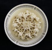 A Chinese export ivory `flower` dish, of circular form carved in high relief with a chrysanthemum