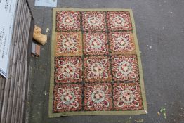 A French? woolwork panel, decorated with panels of flowers, on an olive ground, 9ft 11in by 7ft