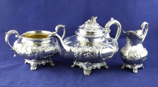 An early Victorian silver three piece tea set, of squat circular form, embossed with floral