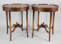 A pair of oval satinwood lamp tables, with blind fret carved frieze and pierced stretchers, W.1ft