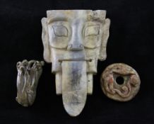 Two Chinese jade carvings and a serpentine mask, the first a green celadon and brown jade carving of