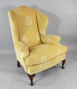A Georgian style wing armchair, with yellow fabric upholstery, on cabriole legs