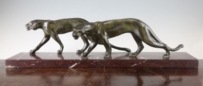 An Art Deco spelter figure group of two panthers, on red marble rectangular base, signed M. Font,