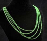 A four strand multi rough facet cut green garnet necklace, with silver clasp, 16in.