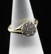 A gold and diamond cluster flowerhead ring, with pierced shoulders and set with ten stones, size O.