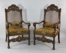 A pair of carved oak Carolean style elbow chairs, with cane backs, scrolling arms and brown