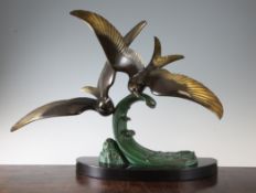 An Art Deco painted and patinated bronze figure group of a pair of terns on the crest of a wave,