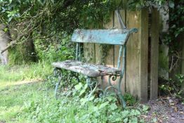 A small 19th century green painted cast iron garden bench, with distressed wooden slats, W.2ft 8in.