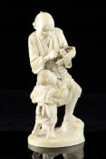 A Japanese ivory group of a man and a boy, Meiji period, the man holding a basket of grapes, the boy