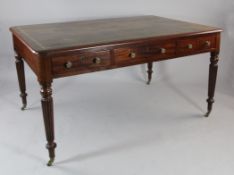 A Victorian mahogany library table, with gilt tooled writing surface over three frieze drawers