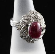 A 14ct white gold, cabochon ruby and diamond set dress ring, of foliate design, size K.