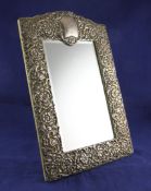 An Edwardian repousse rectangular silver mounted easel mirror, with engraved dated monogram and