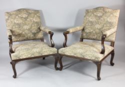 A pair of George III style Gainsborough chairs, with machine tapestry fabric, with carved scroll